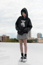 Load image into Gallery viewer, goth girl wearing black hoodie with three eyed mutant cat and armoured battle monster alt fashion design named THE CAT & THAT